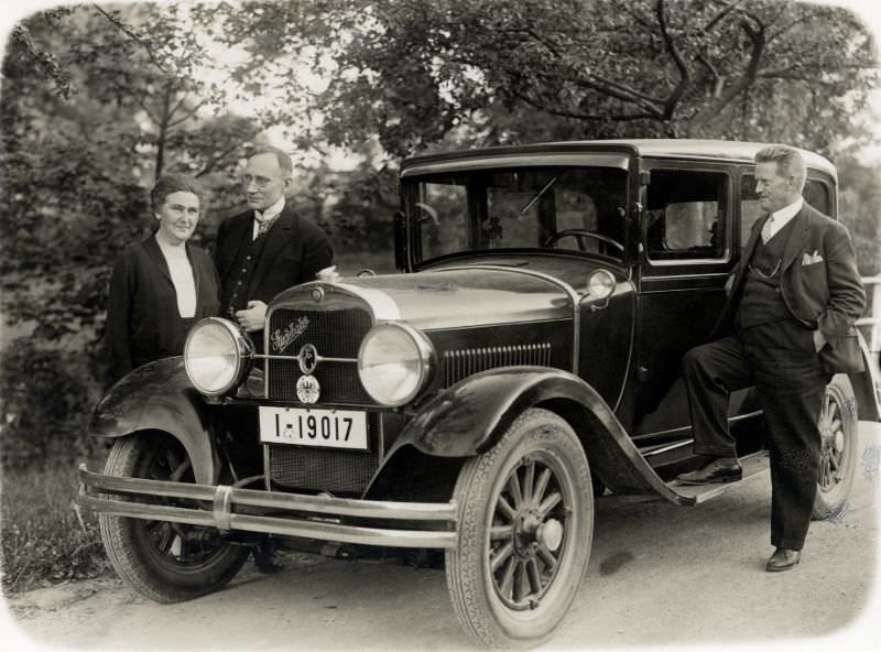 Three members of a German middle-class family posing with a 1929 Erskine by Studebaker on a gravel road in the countryside, July 14, 1929