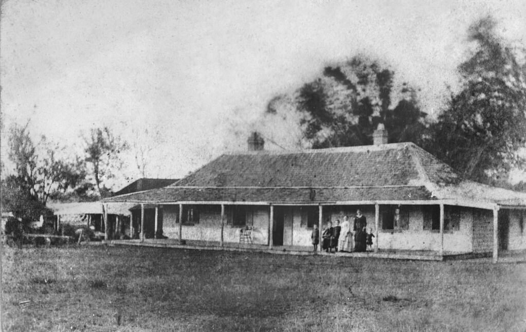 Mrs White, with three children and members of domestic staff, on the verandah of Old Beaudesert Homestead