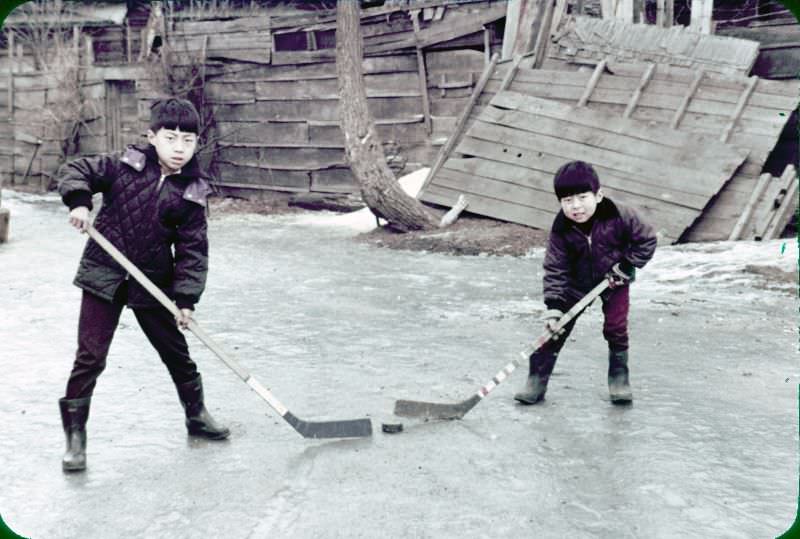 Two boys playing ice hockey