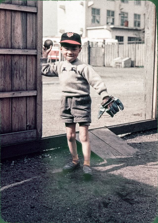 Boy with a baseball glove, baseball bat, and Yomiuri Giants cap