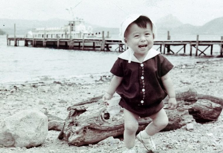 Child running along a shore near a pier