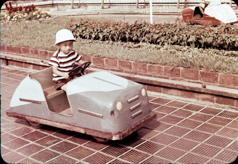 Little boy in a hat driving a metal toy car
