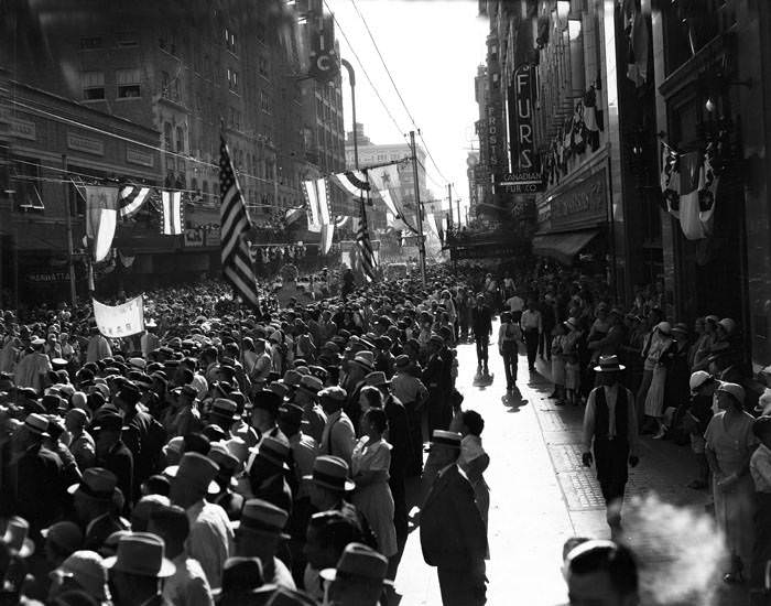 Crowd watching Battle of Flowers Parade in 200 block of E. Houston Street, San Antonio,. 1936