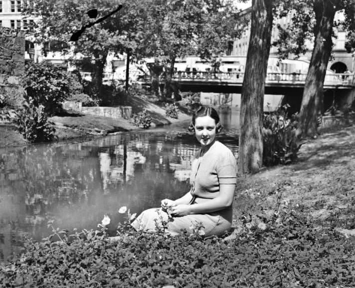Mrs. Donelson Gillis seated on the banks of the San Antonio River, along the side of Crockett, 1938