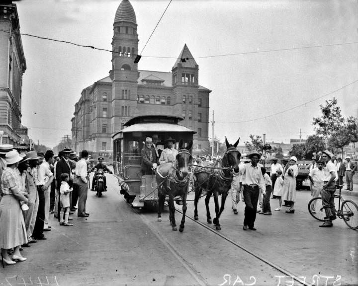 Ed Rivas with mule-drawn streetcar at Main Plaza with Bexar County Courthouse in the background, 1933