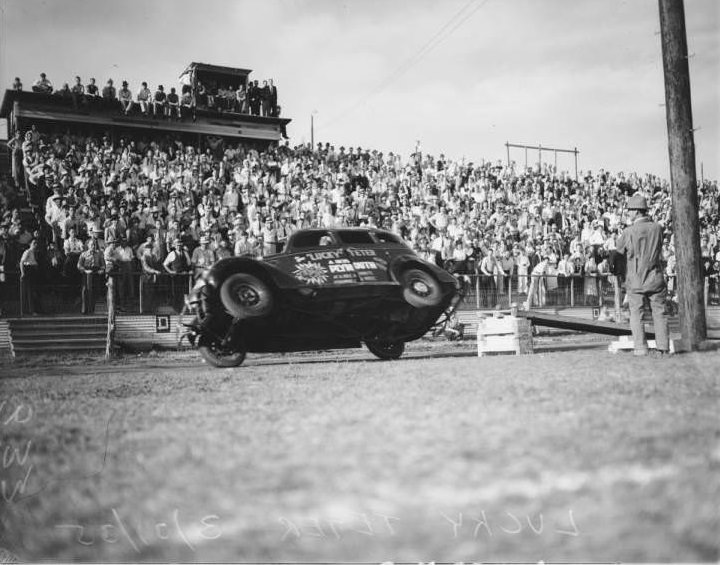 Lucky Teter, a daredevil automobile stunt driver, attempting to turn over a 1935 Plymouth 4 drive car at Hell Drivers exhibition at Eagle Field.