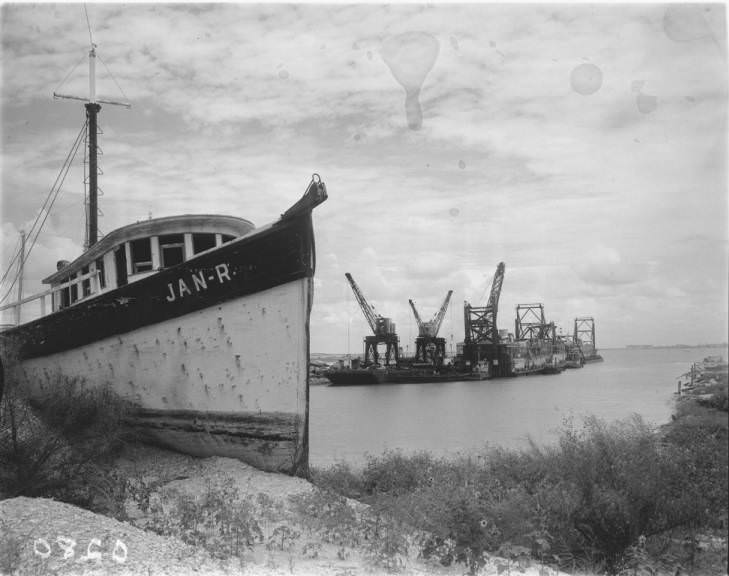 A boat with a construction site in the background at Port Lavaca, 1936
