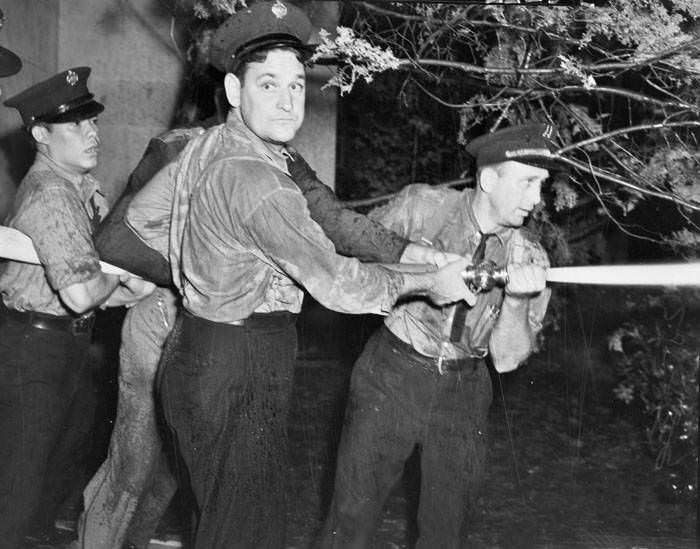 Firemen turn hoses on the rioters outside Municipal Auditorium, San Antonio, Texas, 1939