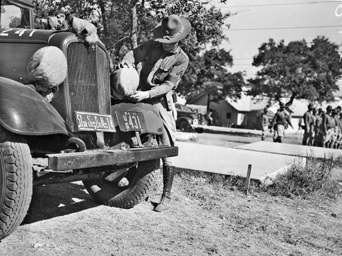 Pvt. E.G. Clohecy placing covers on headlights, 1937