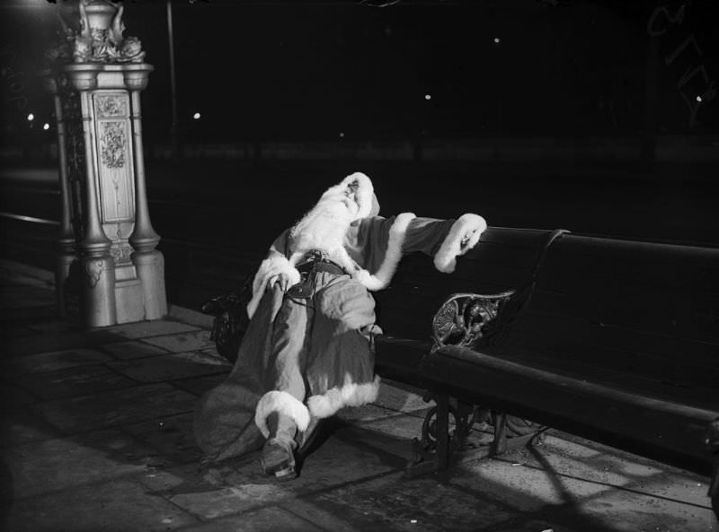 A man in Santa Claus costume sleeping on a bench, circa 1940