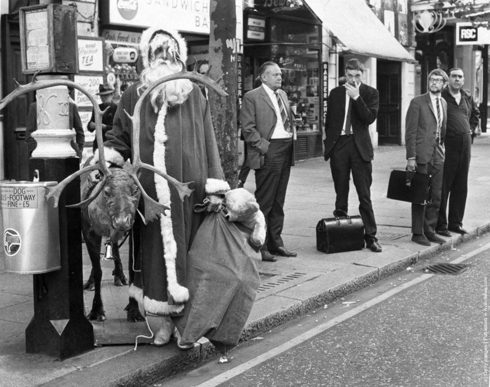 Father Christmas waiting for a bus in the London West End with his reindeer and a sack of presents, 12th August 1970