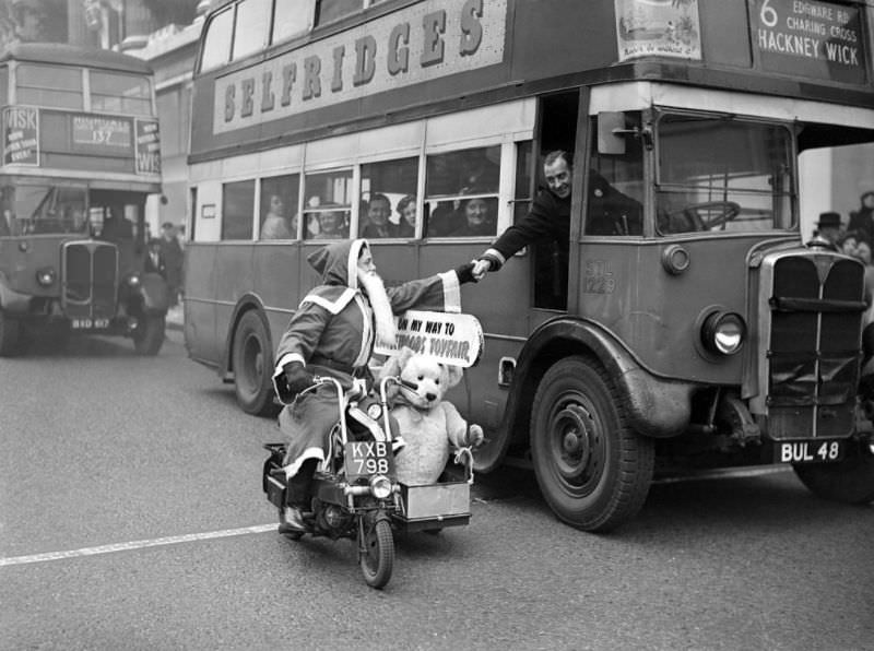 A bus driver shaking hands with Father Christmas passing by on his scooter, London, 1949. (Reg Speller)