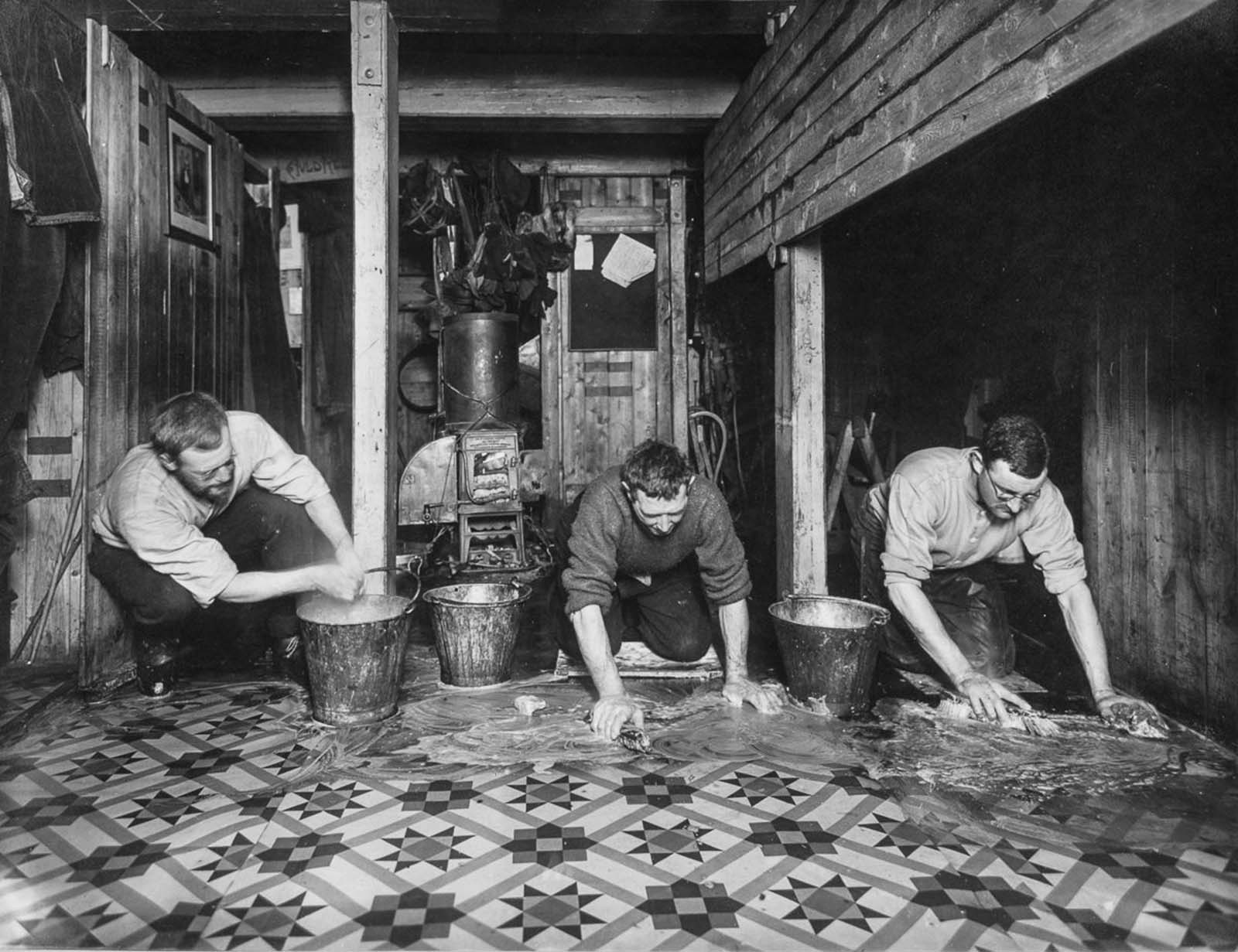 James Wordie, Alfred Cheetham and Alexander Macklin scrub the floors of the “The Ritz” aboard Endurance.