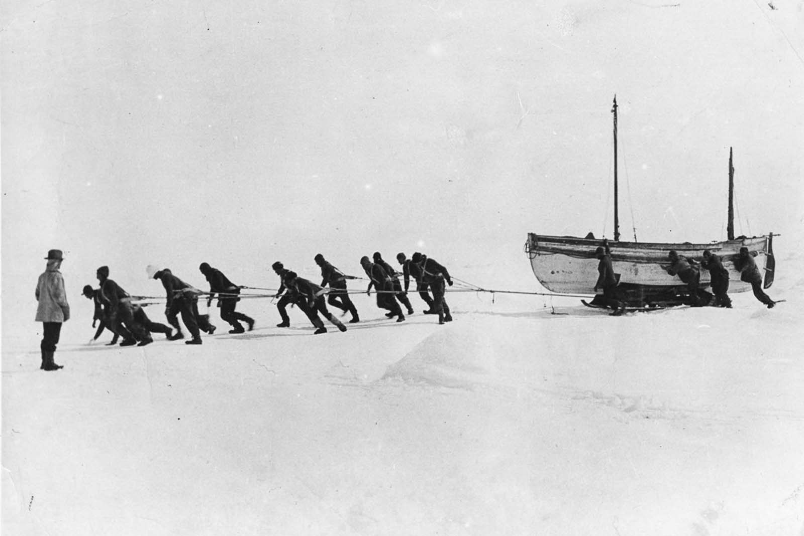 Crew members haul one of the lifeboats across the ice after the loss of Endurance.