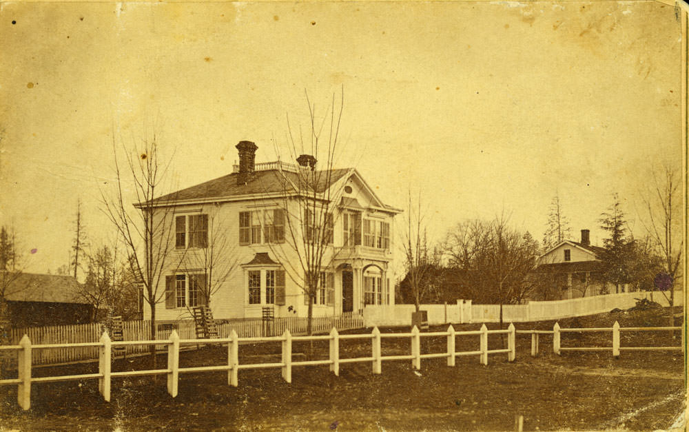 Two story white clapboard home, identified as the McElroy Home on 702 Washington Street, Olympia, 1874.