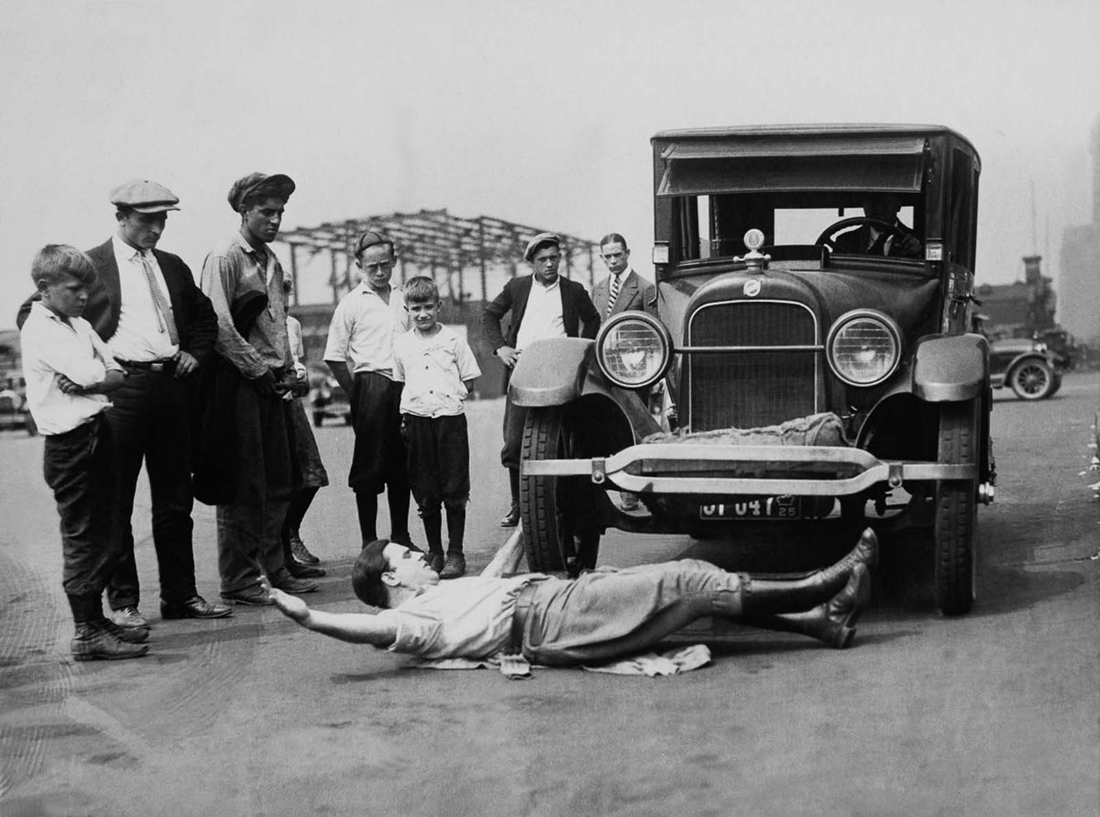 Galen Gotch trains for the Strongman World Championship In New York by being run over by a car, 1920.