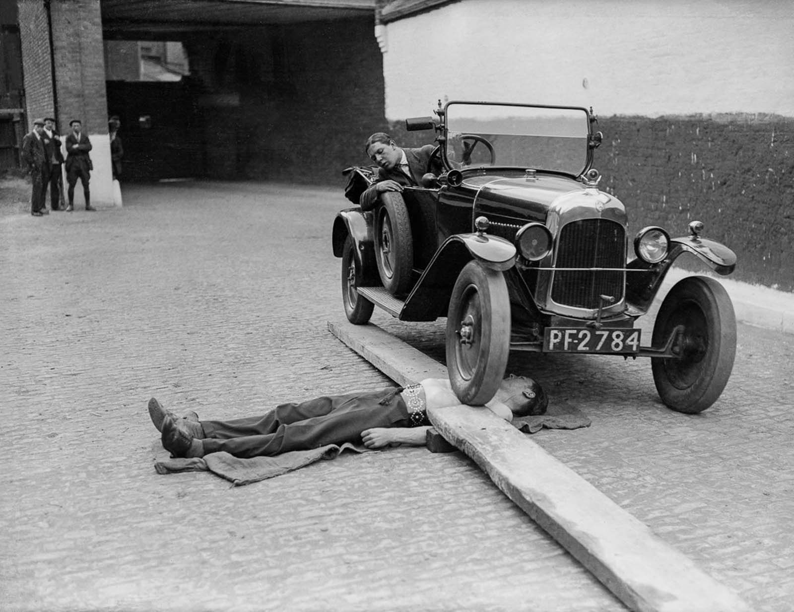 J. Rolleano bears the weight of a Citroen car running over his chest, 1932.