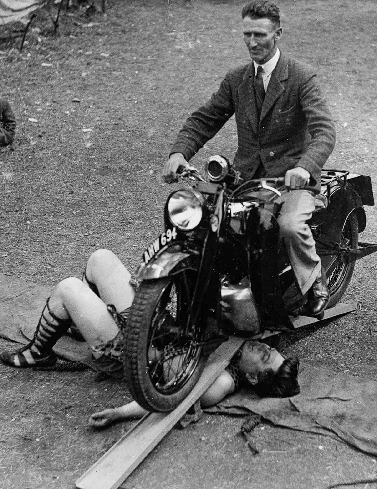 Samson Brown, “the world’s strongest man,” lets a motorcycle run over him, 1934.