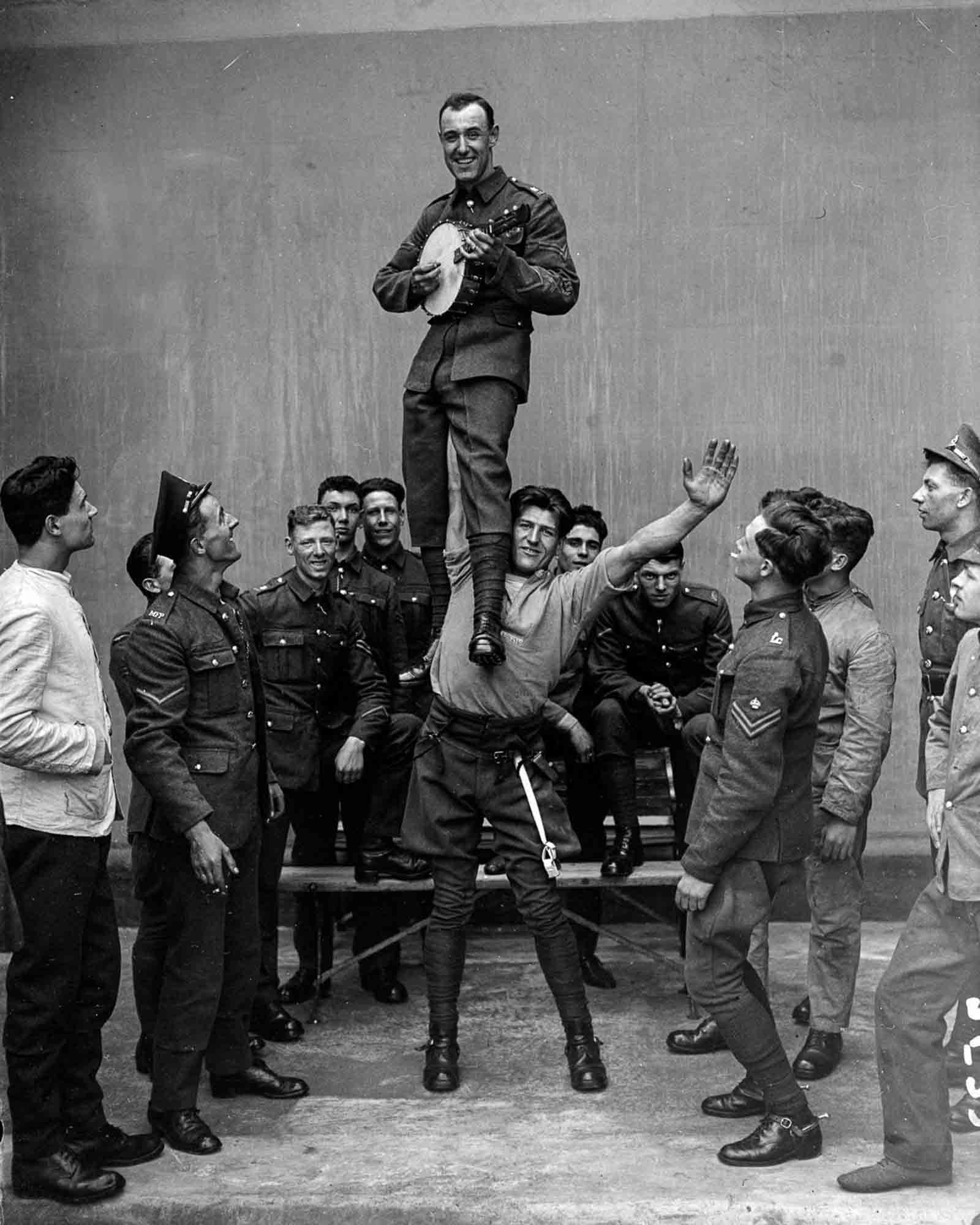 C. Attenborrow of the Royal Horse Guards, considered to be the strongest man in the British Army, holds a comrade up in the air with one hand, 1927.