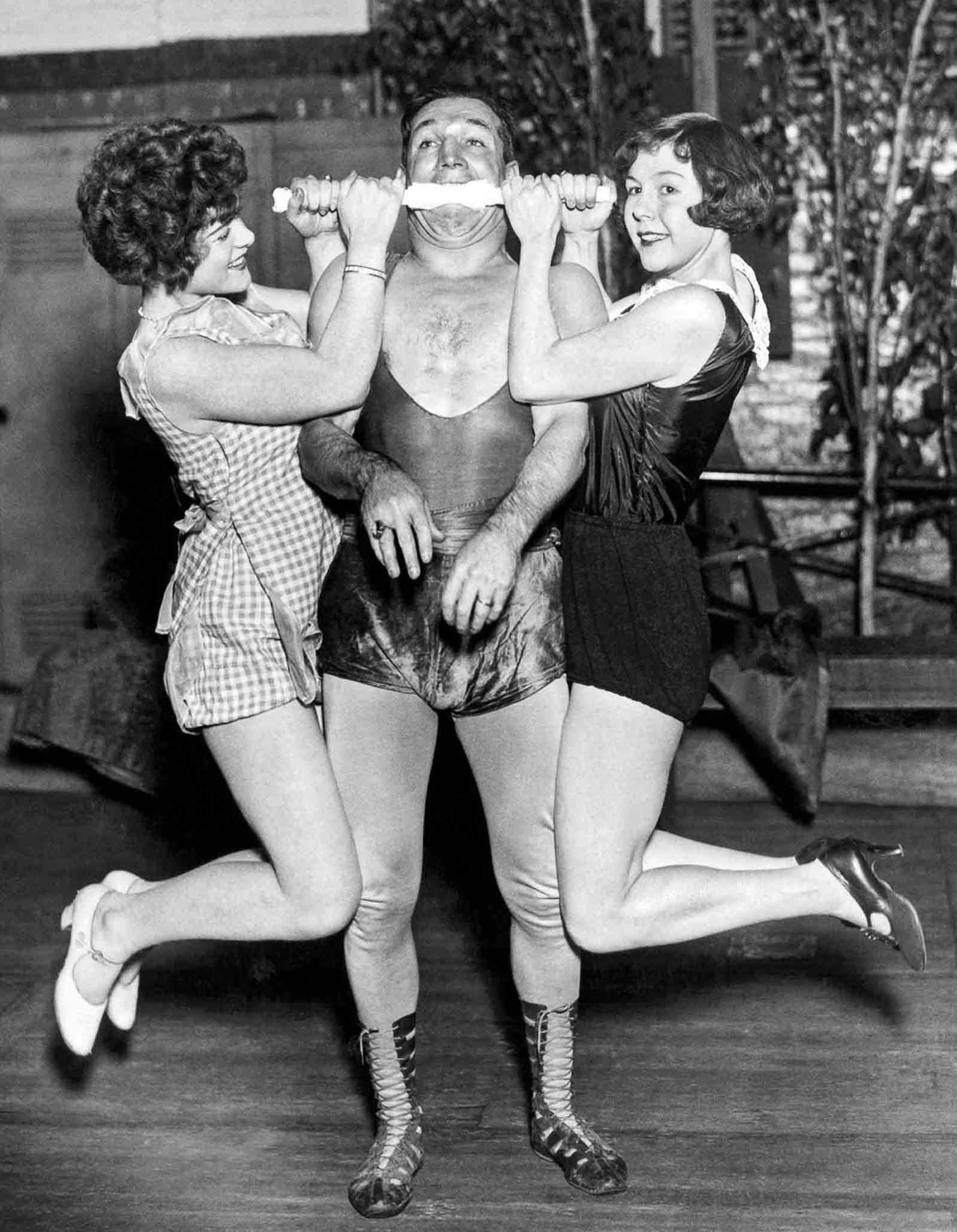 Edward Reece holds up two women with his teeth, 1927.