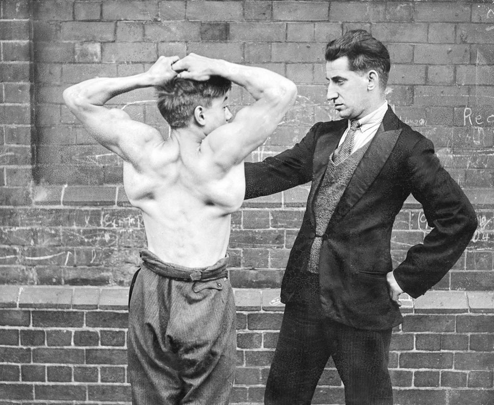 Lewis Clark, “the strong boy,” shows off his back muscles, 1930.