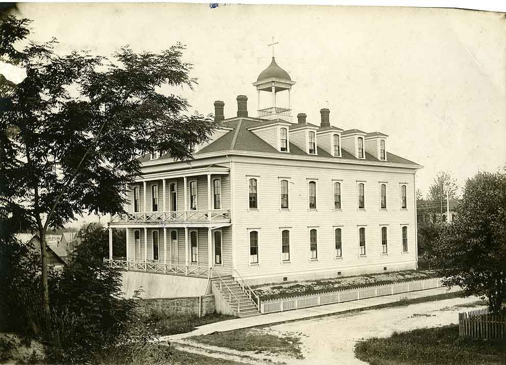 A large two-story building, with sets of gables at roofline and a cupola, identified as the St. Michael's convent in Olympia, 1900s