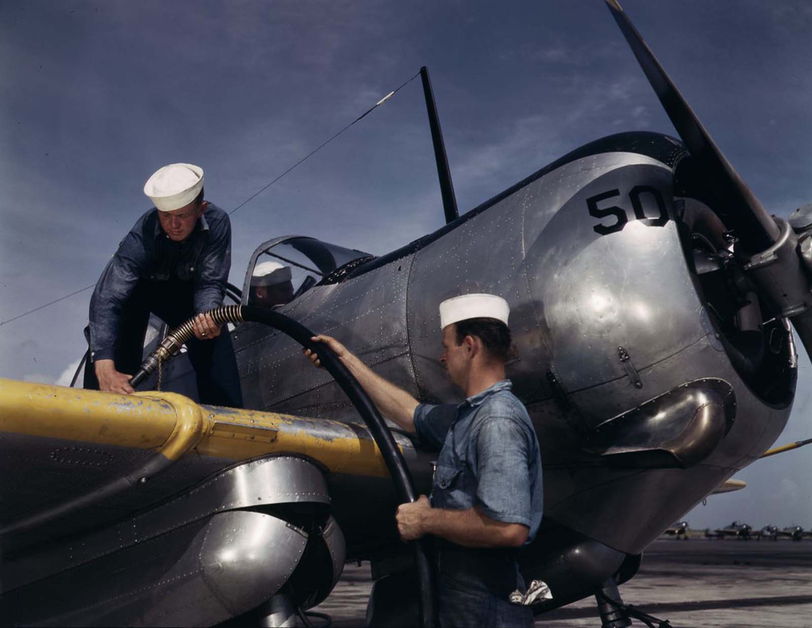 Sailor mechanics refuel an SNC advanced training plane.