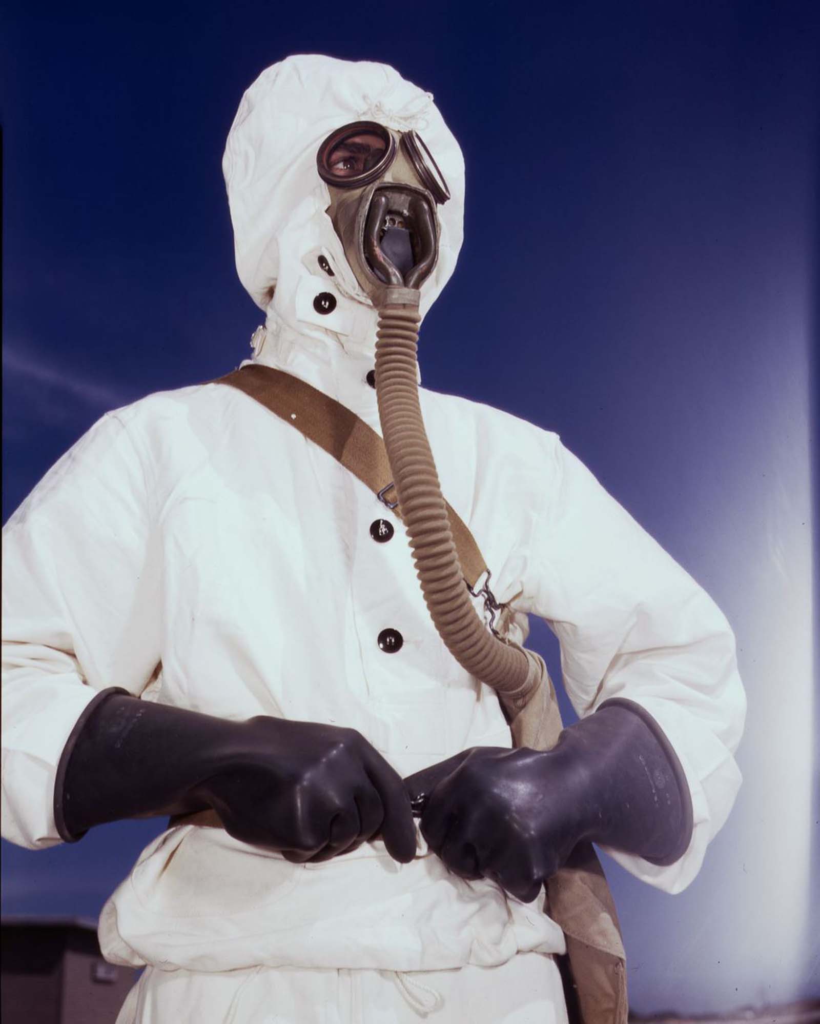 A sailor tries on a new type of protective clothing and gas mask for use in chemical warfare.