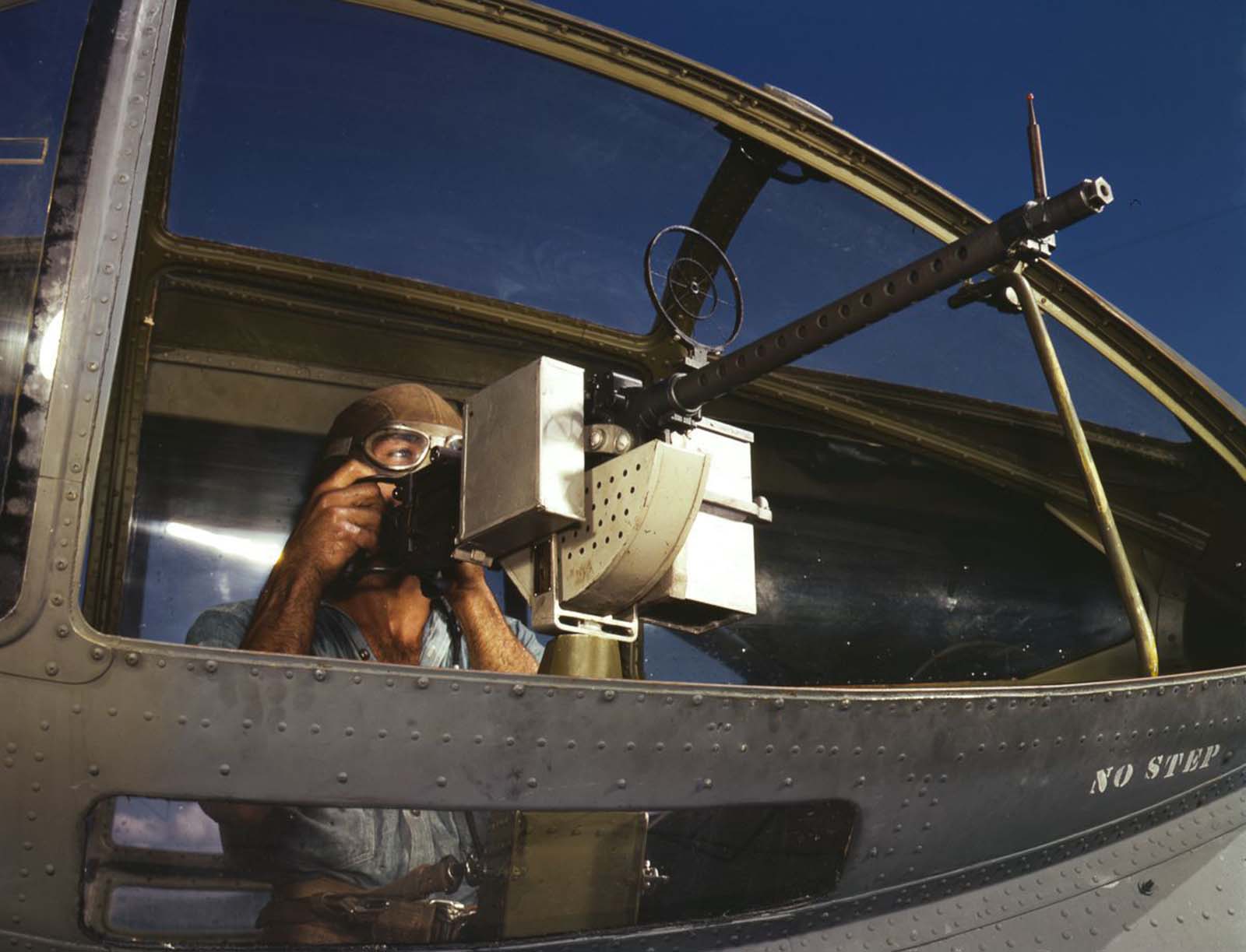 Jesse Rhodes Waller, A.O.M., third class, tries out a 30-caliber machine gun he has just installed in a Navy plane.