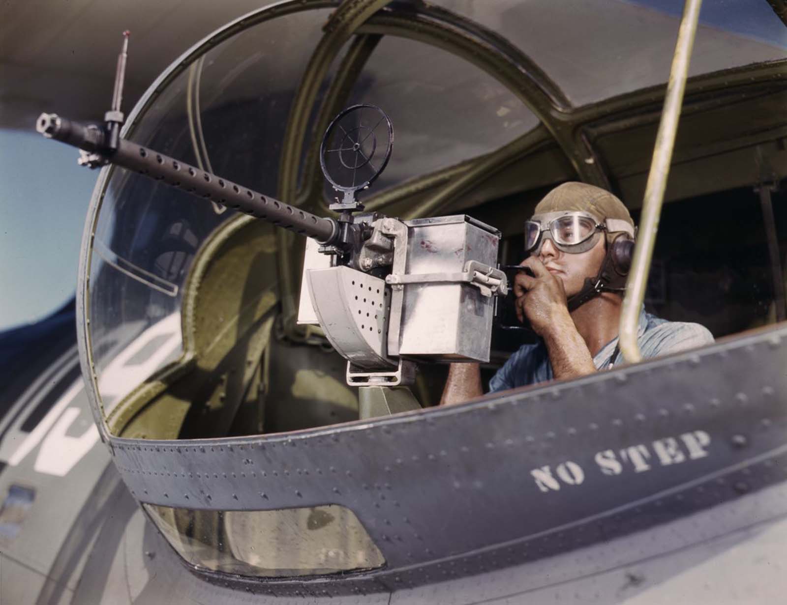 Jesse Rhodes Waller, A.O.M., third class, tries out a .30-caliber machine gun he has just installed on a Navy plane.