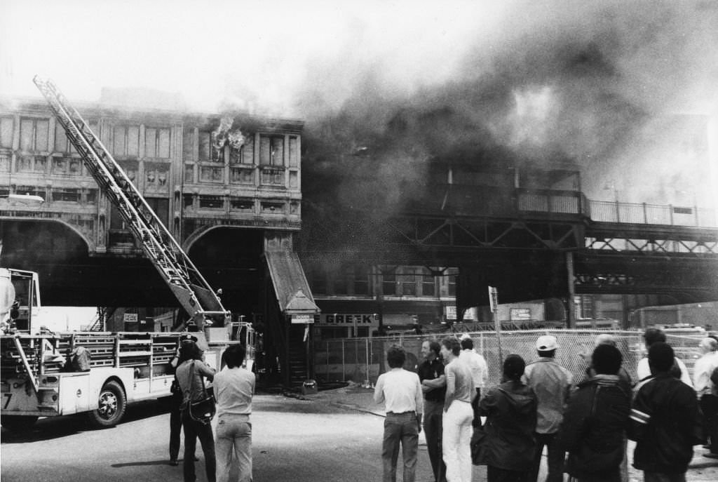 People watch a three-alarm fire at the MBTA Station on Dover Street in the South End of Boston, May 6, 1962.