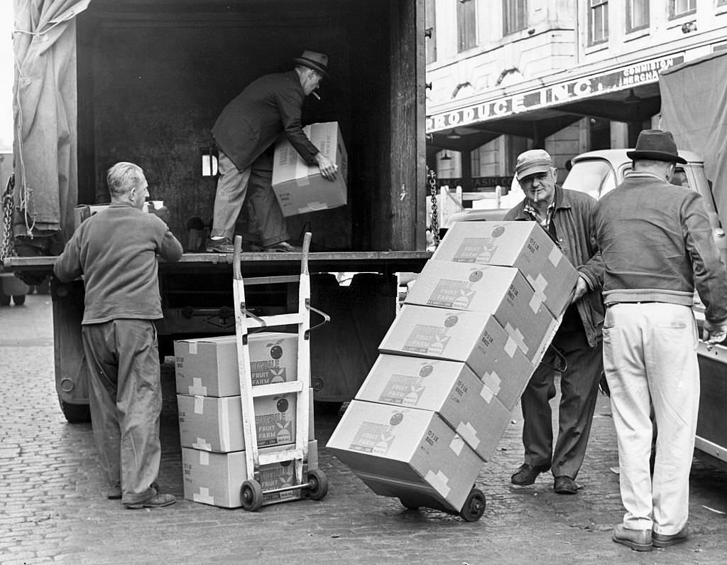 Men load boxes into a truck at the Faneuil Hall market on Sept. 25, 1962.