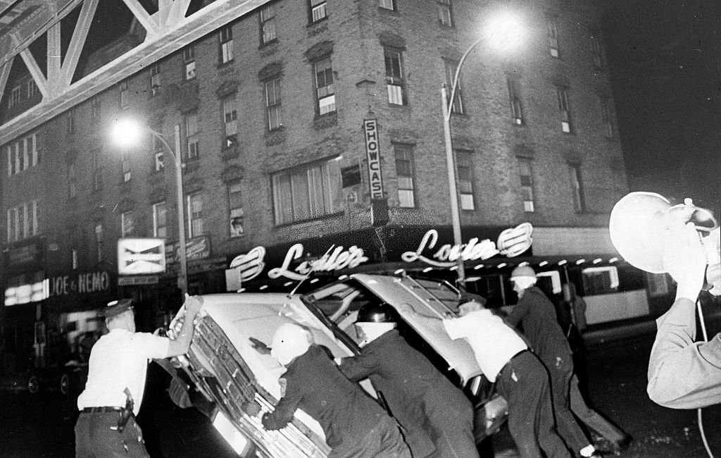 Police right a car overturned by rioters at corner of Washington and Northampton Streets in Boston on June 4, 1967.