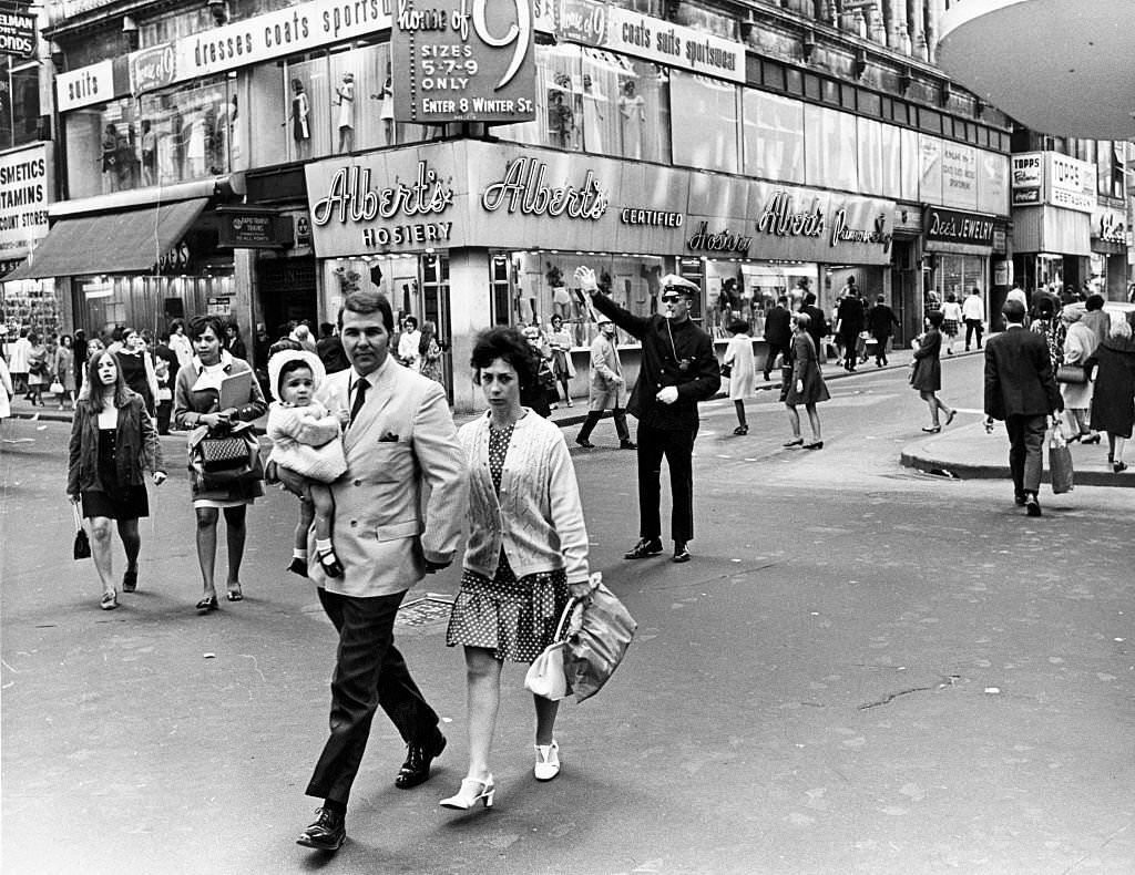 A police officer tries to direct foot traffic at the intersection of Washington Street and Summer Street in Boston on May 13, 1969.