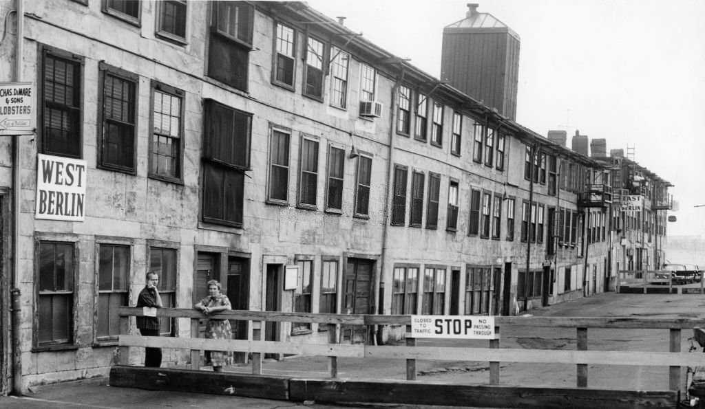 J.W.S. Cox, left, and Ms. Helen Sherman, right, lean on a new fence put up at the T Wharf in Boston, Sept. 5, 1961.