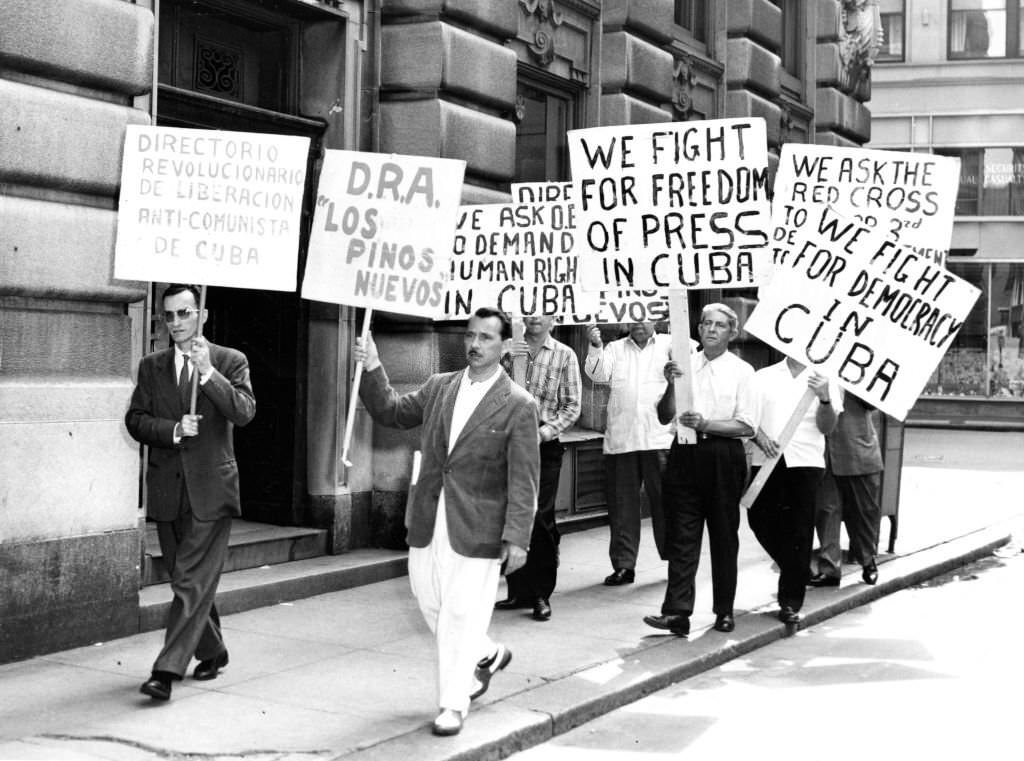Demonstrators hold signs while marching in front of the Cuban consulate in Boston in protest of Cuban Prime Minister FIdel Castro on June 5, 1960.