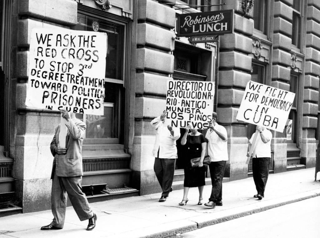 Demonstrators hold signs while marching in front of the Cuban consulate in Boston in protest of Cuban Prime Minister Fidel Castro on June 5, 1960.