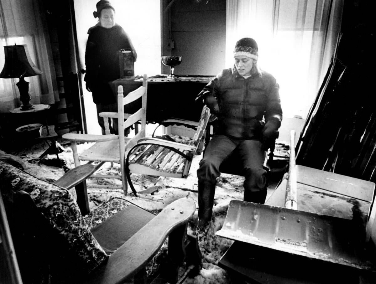 Nancy Erickson sat in the living room of her parents’ damaged summer home on Edgewater Drive in Quincy (Hough’s Neck.) Nancy’s mom is in the doorway.