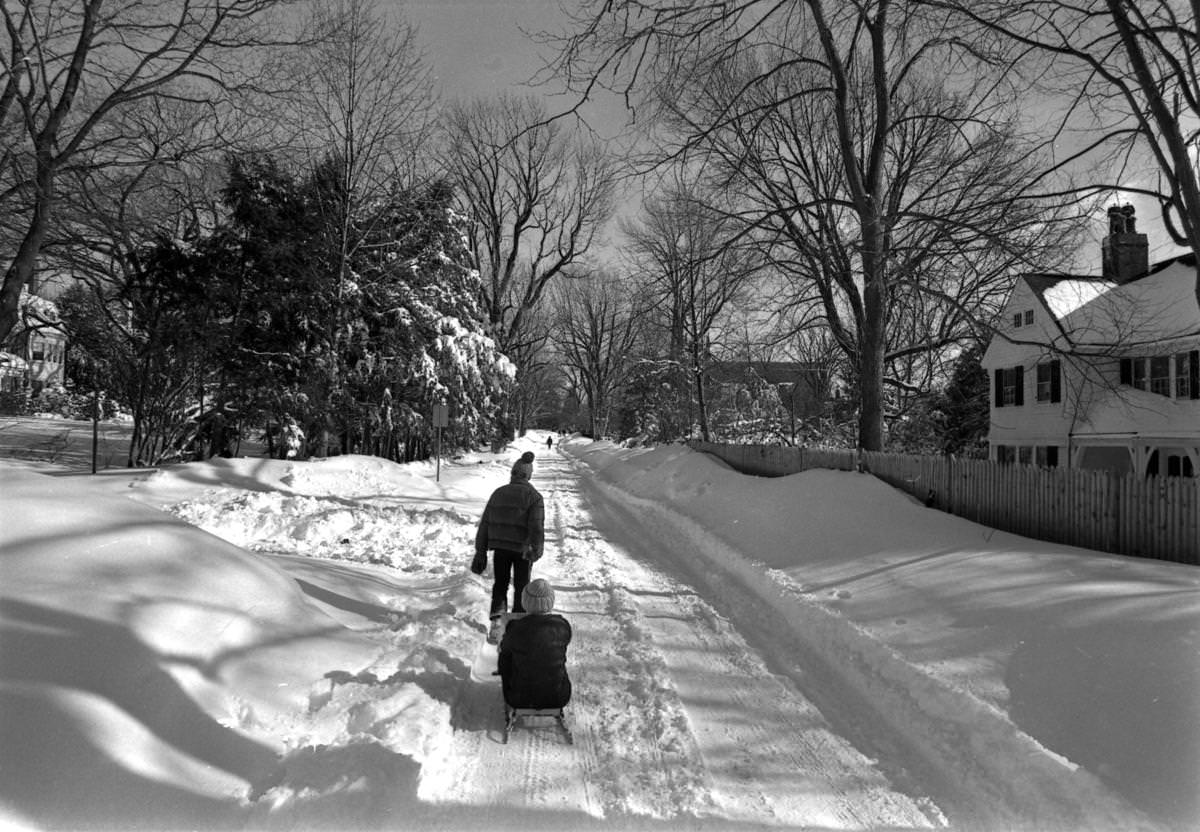 One child pulled another on a sled along a snow-covered road in Newton on Feb. 9.