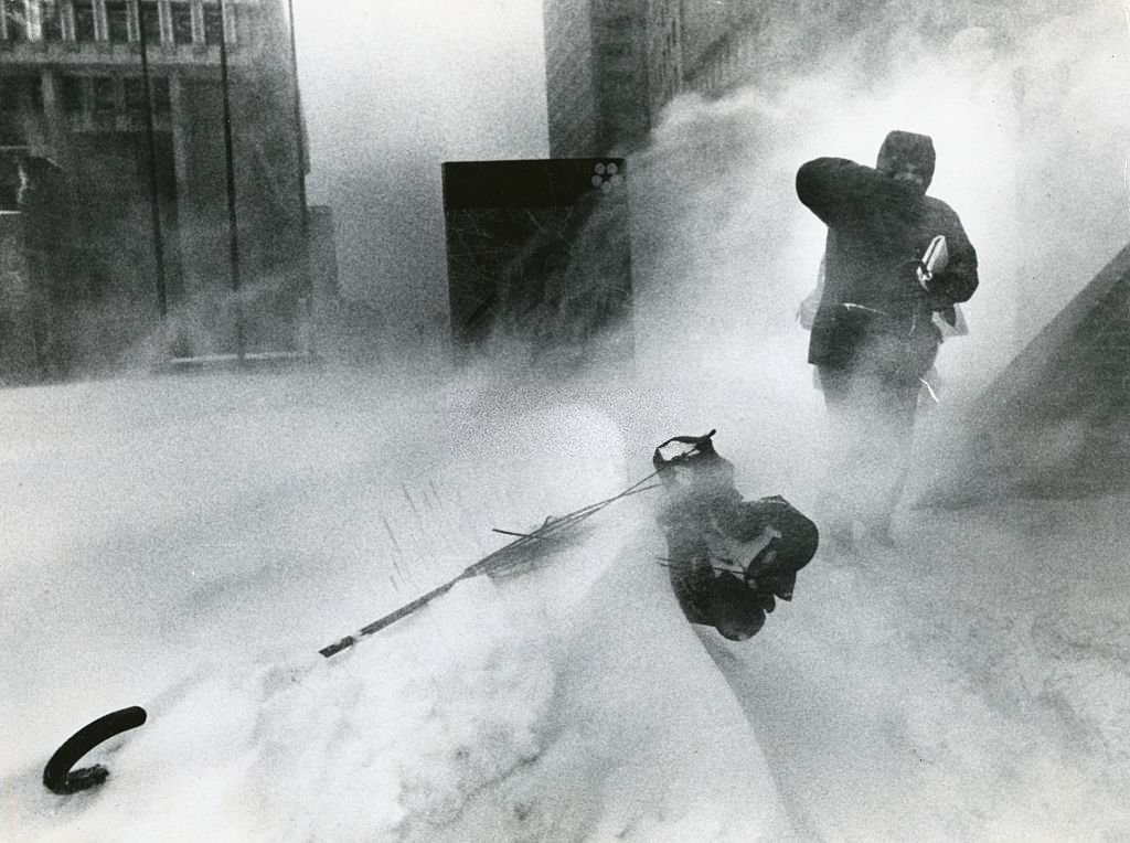 A commuter fights his way to City Hall MBTA Station passed mangled umbrella during a storm in Boston, 1978.