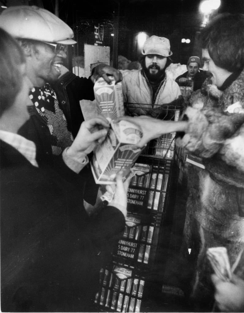 Pete Cole is surrounded by customers looking to buy the milk he is delivering to a store in Boston at midnight on Feb. 10, 1978.