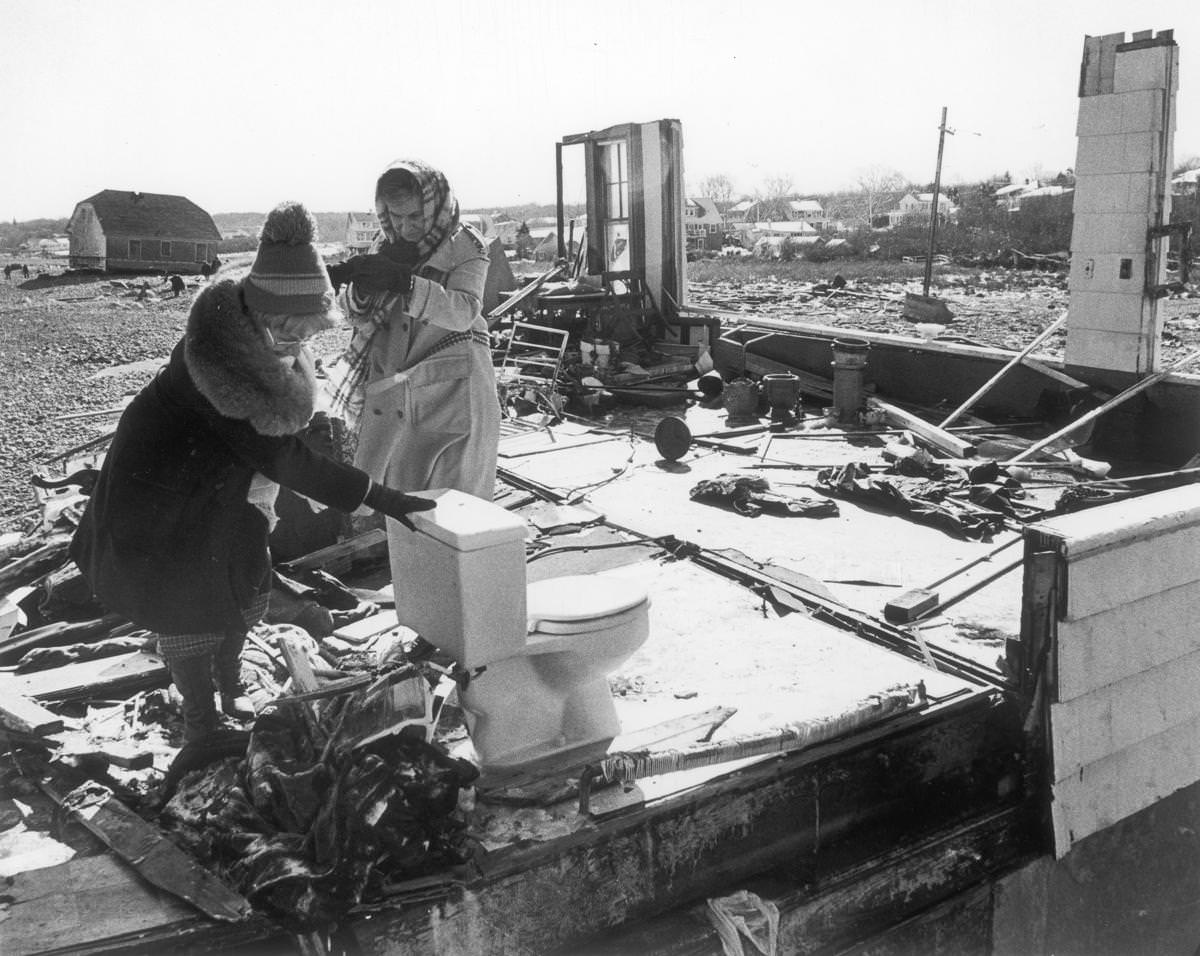 Mrs. Joseph Conley leaned on the only remaining fixture at her destroyed house in Scituate as she left with Mrs. Edward Dailey, with whom she is now staying on Feb. 10.