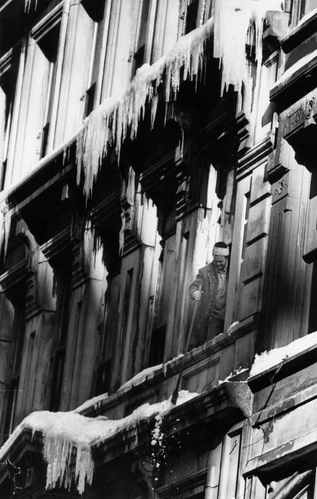Jimmy Hanlow, working for H&H Buildings, breaks ice off a building on Washington Street in Boston on Feb. 18, 1978.