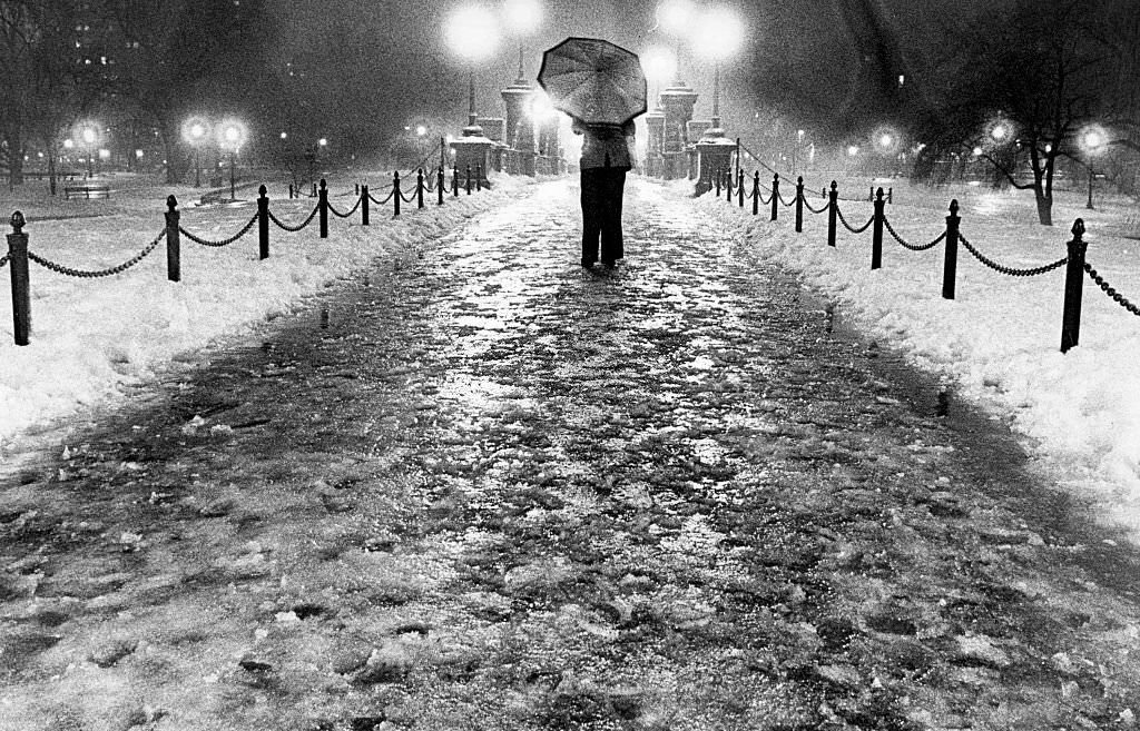 A pedestrian walks down a slushy path in the Public Garden in Boston, 1977.