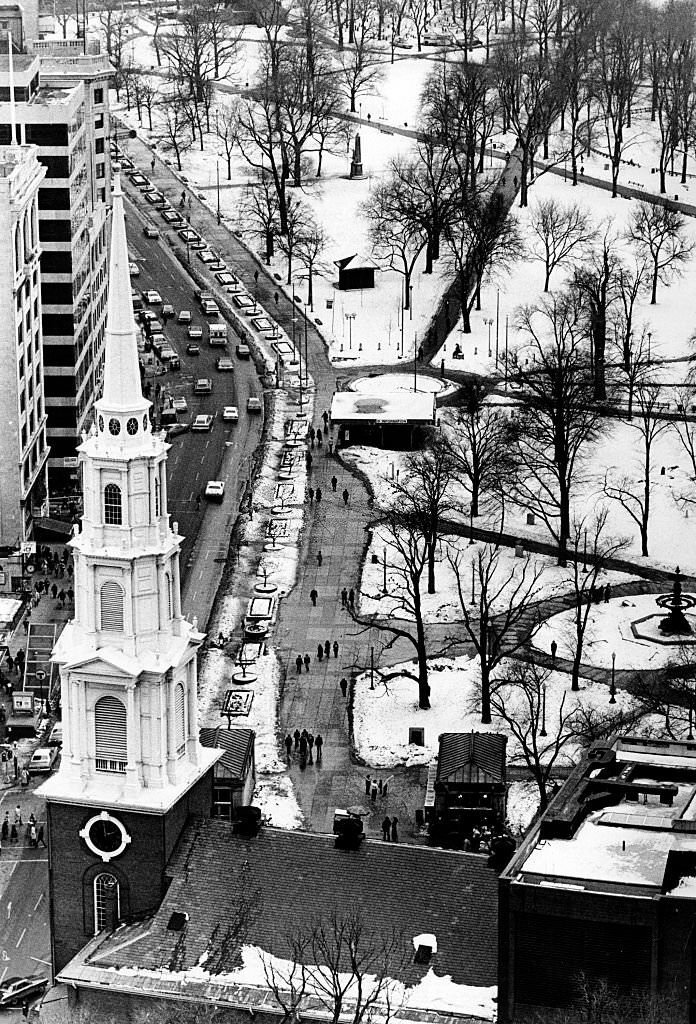 The view from the 24th floor of One Beacon St. in Boston looks out over a the steeple and roof of the Park Street Church, Tremont Street and snowy Boston Common, 1977.