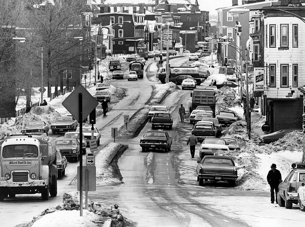 Dorchester Street in South Boston is a wide street made narrow by snow and ice, 1977.