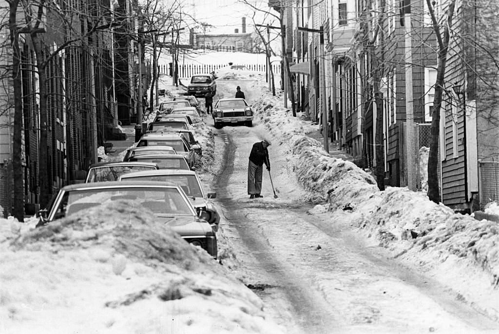A man hacks at ice on a rutted Soley Street in Boston's Charlestown, 1977.