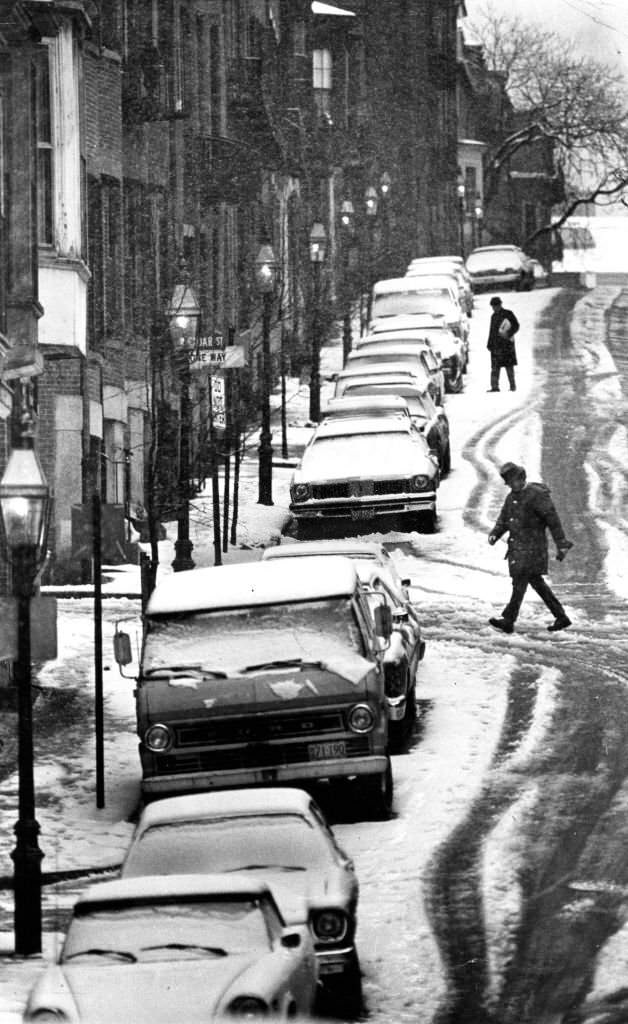 A line of snow-covered cars is pictured along Pinckney Street in the Beacon Hill neighborhood of Boston, 1976.