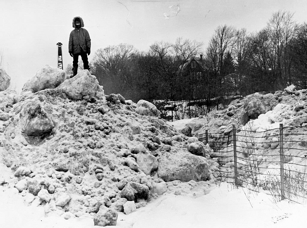 Stephen Bagley, 8, is king of the mountain of snow blocking Grew Avenue in Boston's Roslindale area, 1975.
