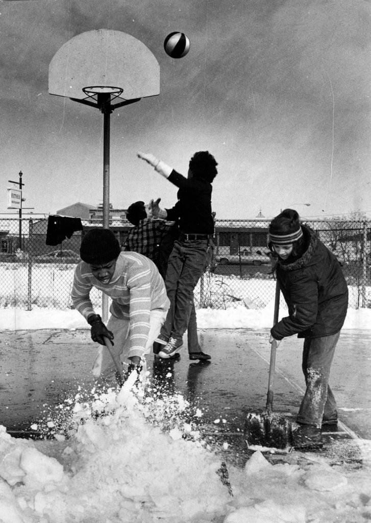 Tony Blaides,15, and Robert Landry, 13, shovel snow away from basketball court in Eustis Park as their friends couldn't wait for the rest of the area to be cleared after a winter storm, Feb. 7, 1975.
